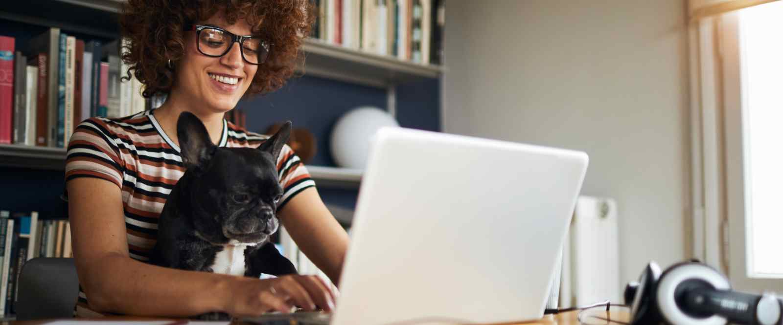 woman holding dog on laptop