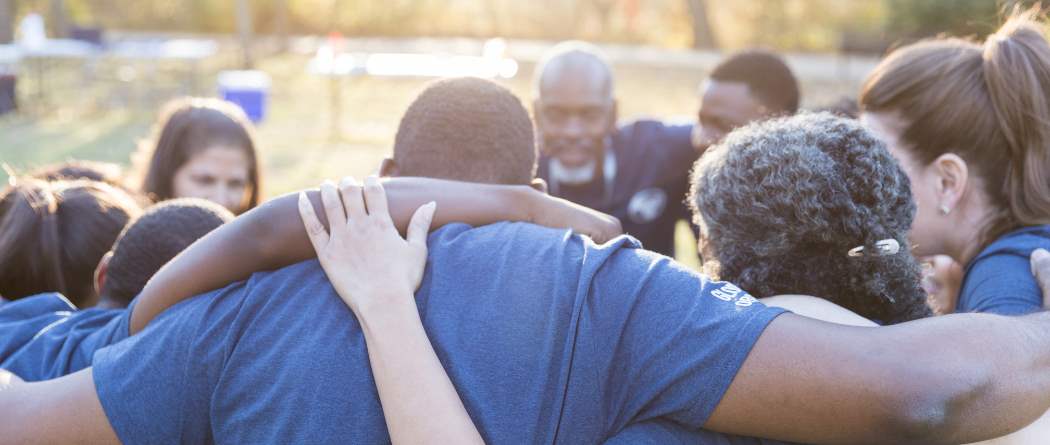 group of people with arms connected