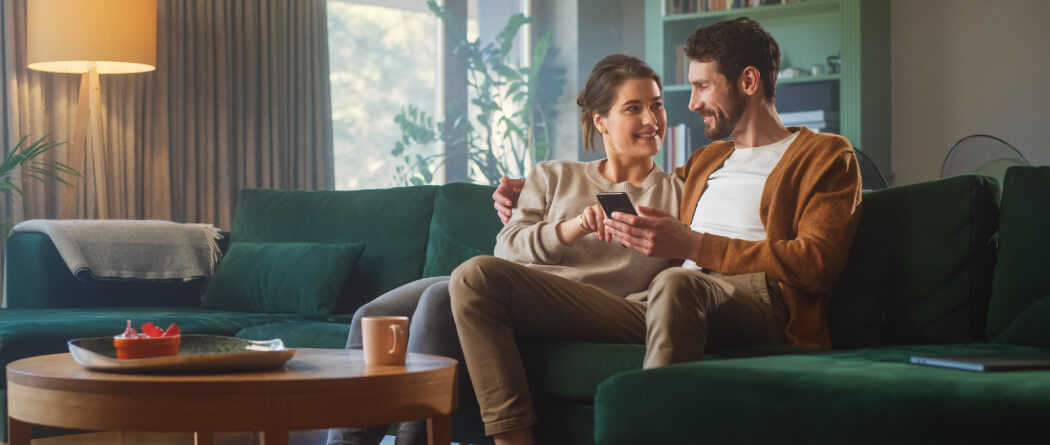 couple on couch looking at phone