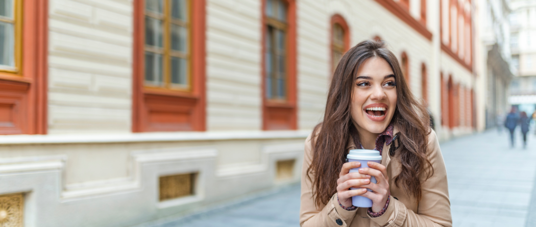 woman smiling holding coffee cup