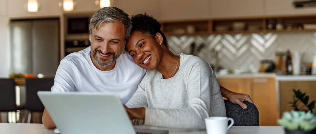 couple looking at laptop smiling